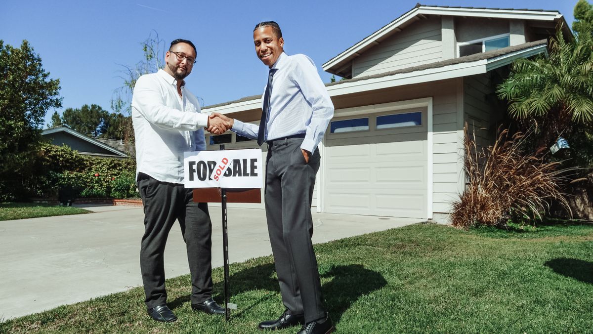 A Home Team agent shaking hands with a client after closing